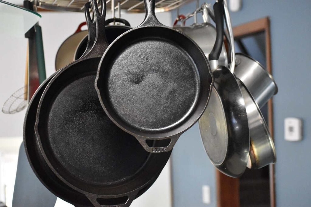 cast iron skillets hanging in the kitchen - season them with vegetable oil - vidi cooking