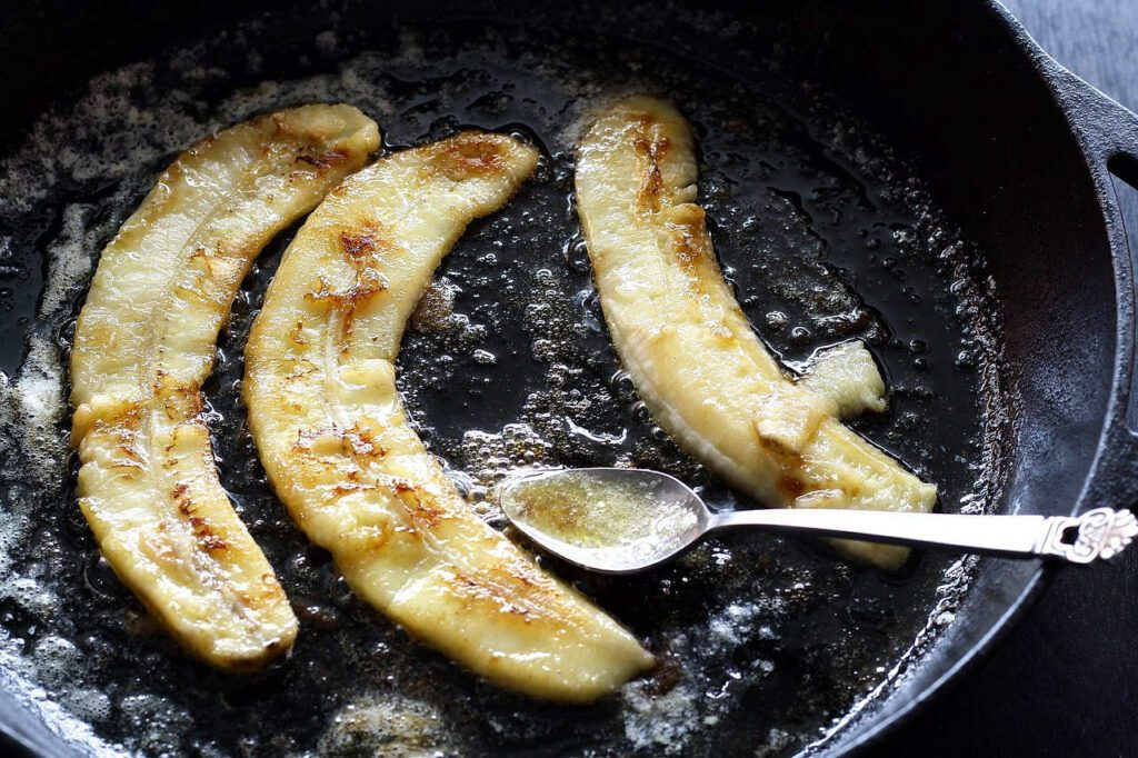 cast iron skillet with bananas - season them with vegetable oil - vidi cooking